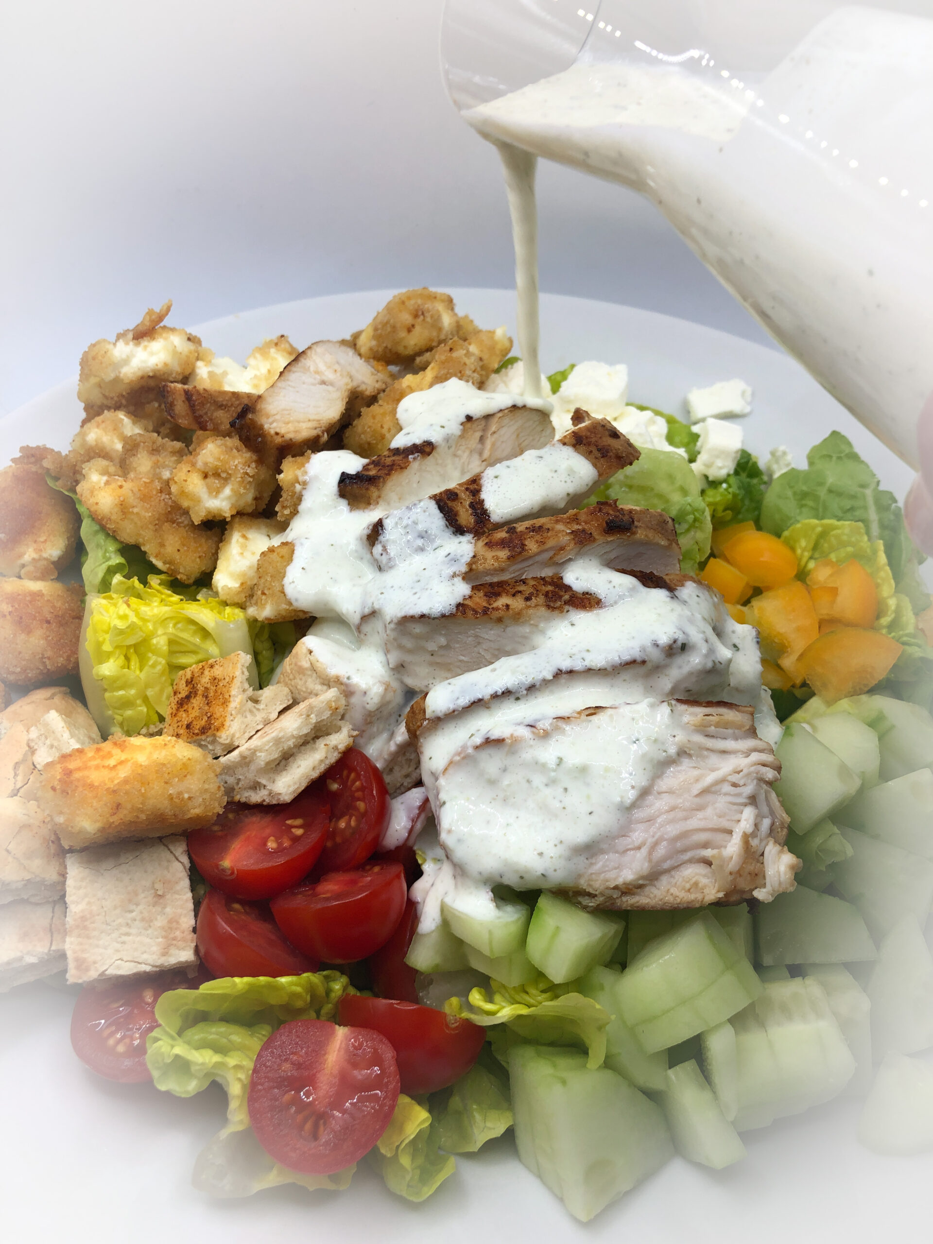 Griechischer Salat mit Pita-Croutons, Tzaziki-Dressing und gebackenen ...
